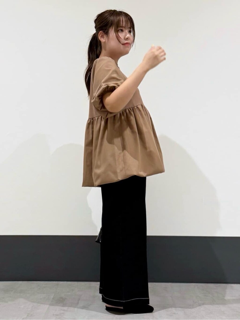ブラウン系のTシャツ/カットソー、ブラック系のデニムパンツ、ブラック系のショルダーバッグを着用したレディースの秋コーディネートの2枚目の写真