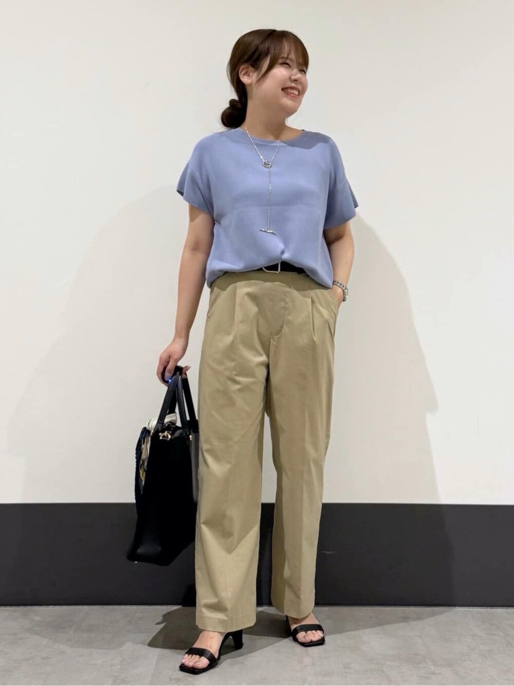 ブルー系のニット/セーター、ベージュ系のその他パンツ、ブラック系のトートバッグを着用したレディースの夏コーディネートの2枚目の写真