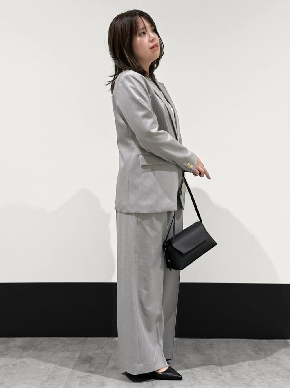グレー系のテーラードジャケット、ホワイト系のTシャツ/カットソー、グレー系のその他パンツを着用したレディースの冬コーディネートの2枚目の写真