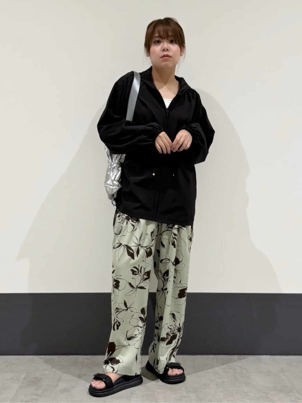 ブラック系のパーカー、ホワイト系のタンクトップ、シルバー系のトートバッグを着用したレディースの夏コーディネートの2枚目の写真