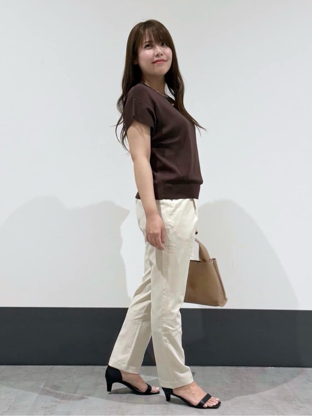 ブラウン系のニット/セーター、ホワイト系のその他パンツ、ブラウン系のショルダーバッグを着用したレディースの夏コーディネートの2枚目の写真