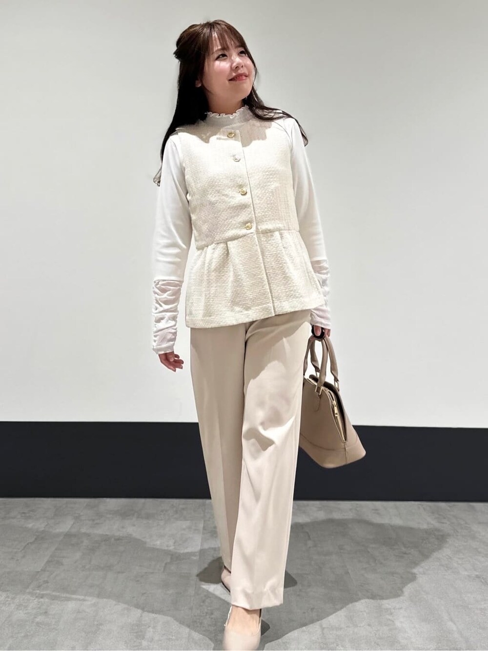 ベージュ系のベスト、ベージュ系のその他パンツ、ベージュ系のショルダーバッグを着用したレディースの春コーディネートの3枚目の写真