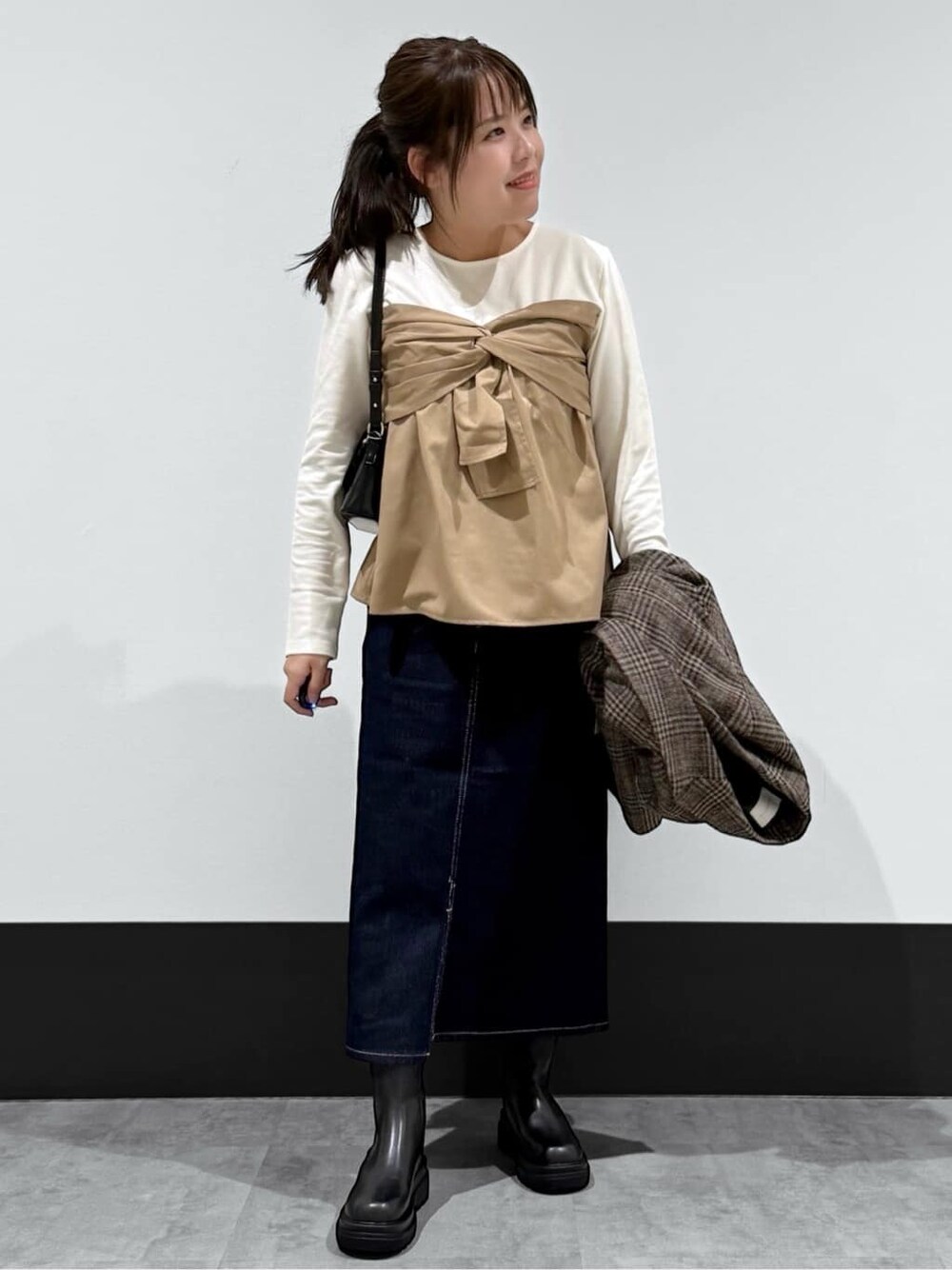 ベージュ系のテーラードジャケット、ベージュ系のTシャツ/カットソー、ブルー系のデニムスカートを着用したレディースの冬コーディネートの3枚目の写真
