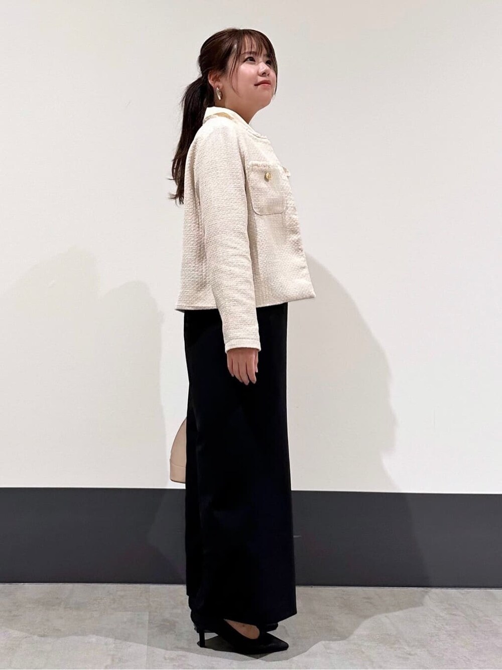 ベージュ系のノーカラージャケット、ホワイト系のシャツ/ブラウス、ブラック系のサロペット/オーバーオールを着用したレディースの冬コーディネートの2枚目の写真