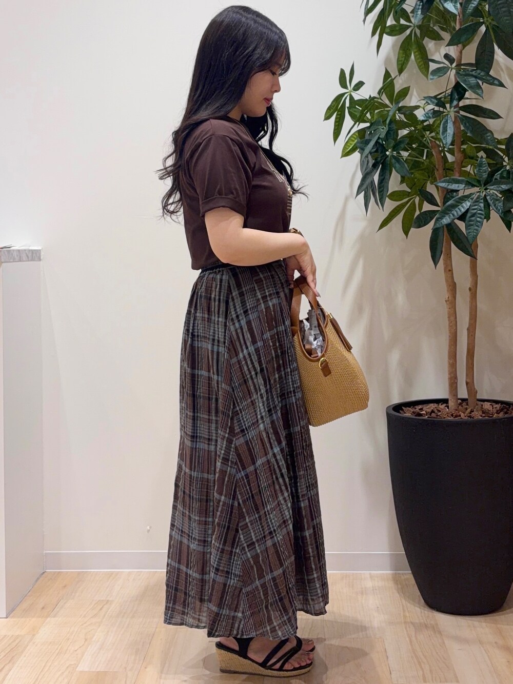 ブラウン系のスカート、ブラウン系のTシャツ/カットソー、ブラック系のサンダルを着用したレディースの春コーディネートの2枚目の写真