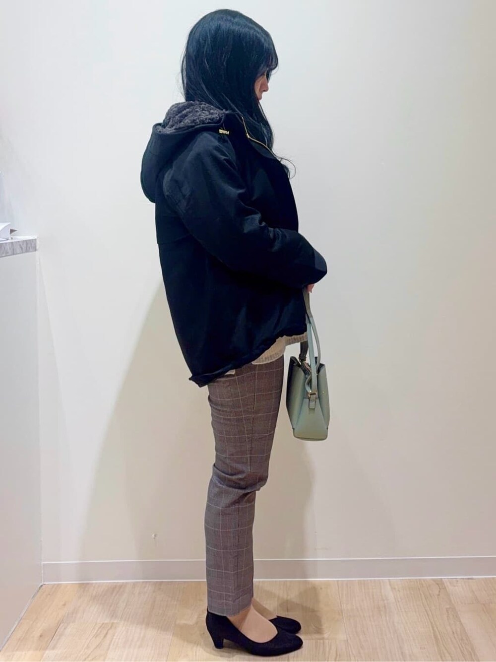 ブラック系のブルゾン、ホワイト系のニット/セーター、ベージュ系のその他パンツを着用したレディースの冬コーディネートの2枚目の写真