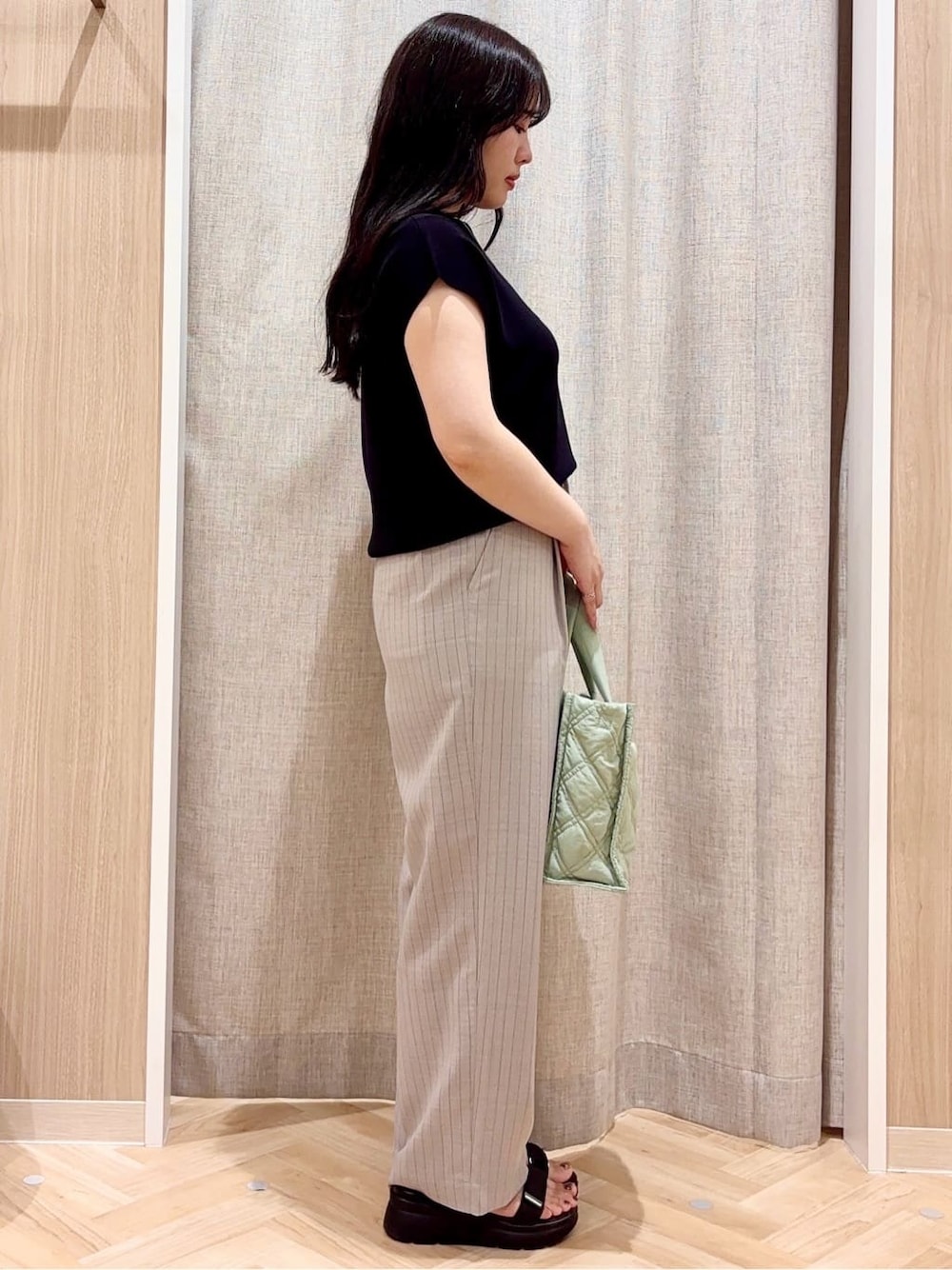 グレー系のその他パンツ、グリーン系のトートバッグ、シルバー系のネックレスを着用したレディースの夏コーディネートの2枚目の写真