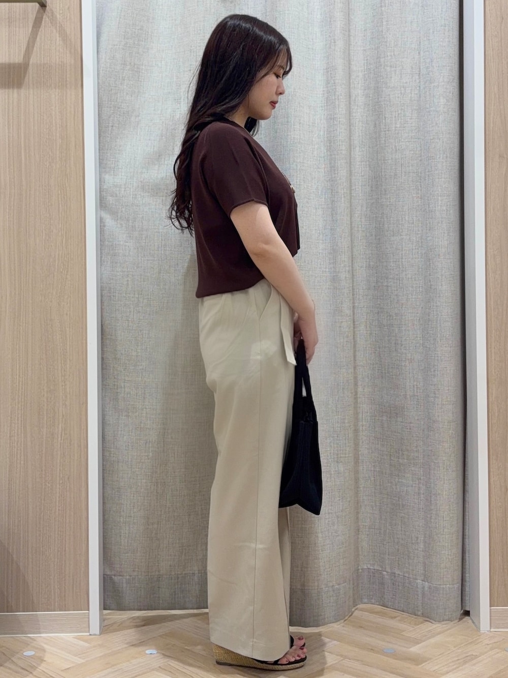 ブラウン系のニット/セーター、ベージュ系のその他パンツ、ブラック系のトートバッグを着用したレディースの夏コーディネートの2枚目の写真