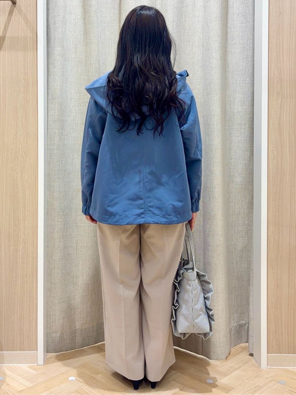 ブラック系のパンプス、ブルー系のブルゾン、ベージュ系のその他パンツを着用したレディースの春コーディネートの3枚目の写真