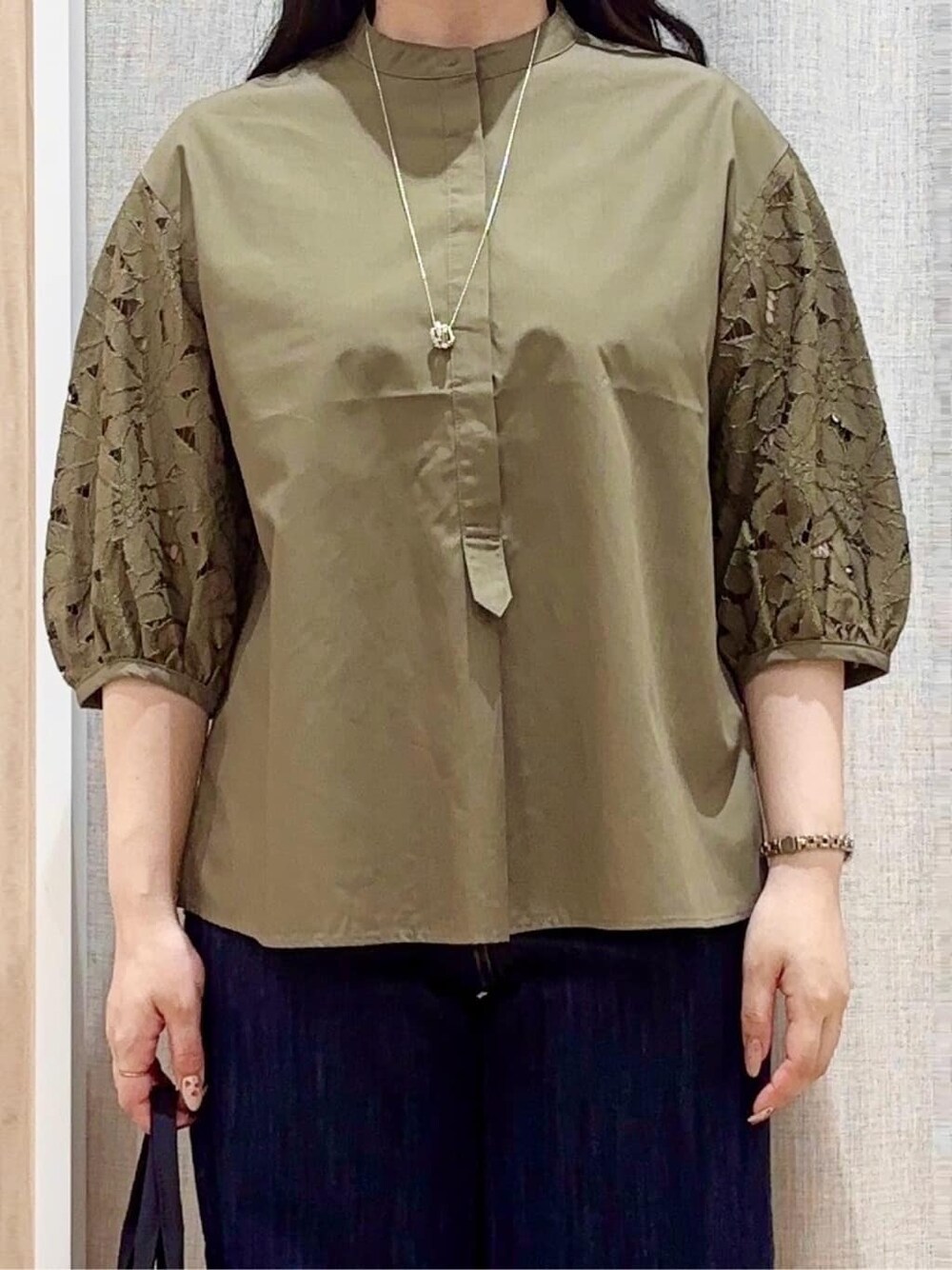 ブルー系のデニムパンツ、ブラック系のトートバッグ、ブラウン系のパンプスを着用したレディースの夏コーディネートの4枚目の写真