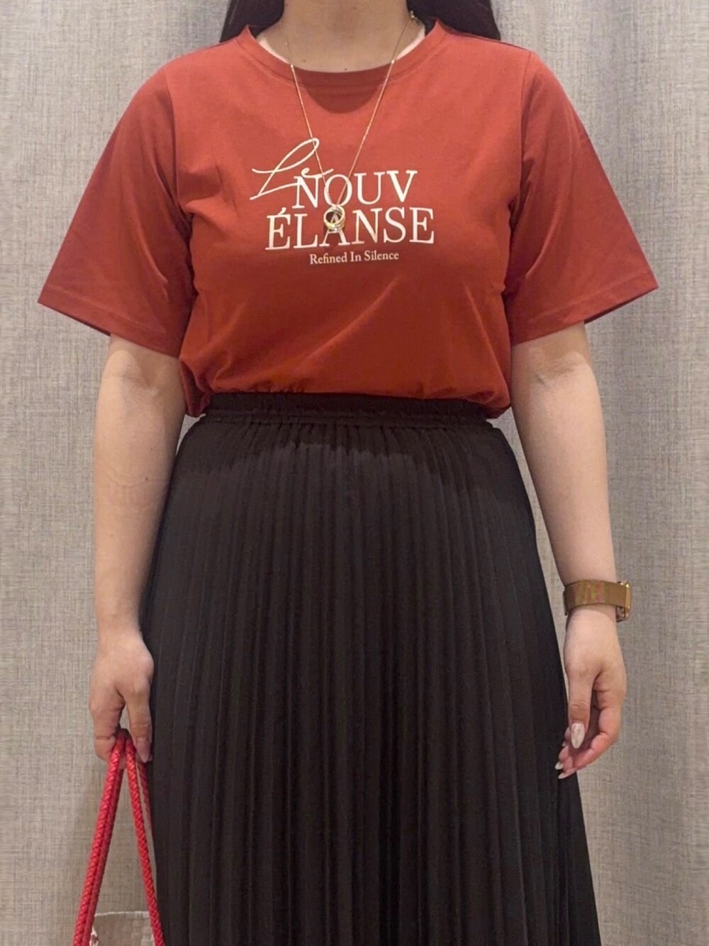 ブラウン系のTシャツ/カットソー、ブラック系のスカート、レッド系のトートバッグを着用したレディースの夏コーディネートの4枚目の写真