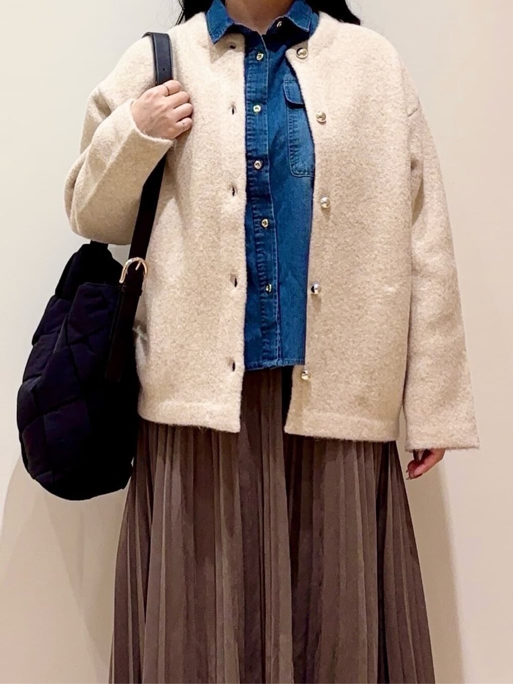 ベージュ系のカーディガン/ボレロ、ブルー系のシャツ/ブラウス、ブラウン系のスカートを着用したレディースの秋コーディネートの4枚目の写真