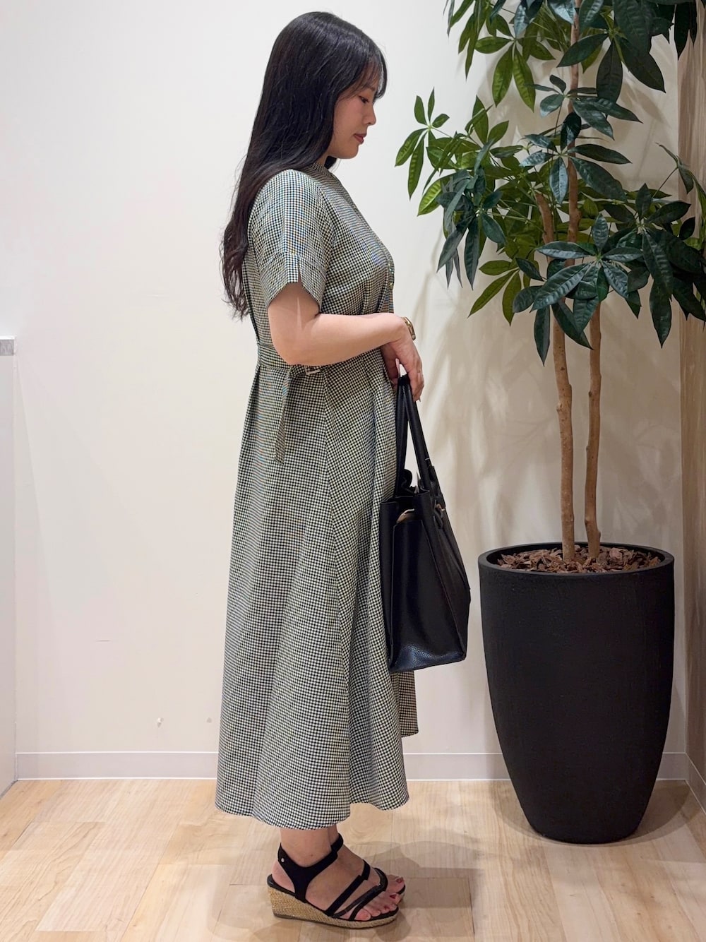 ブラック系のワンピース、ブラック系のトートバッグ、シルバー系のネックレスを着用したレディースの夏コーディネートの2枚目の写真