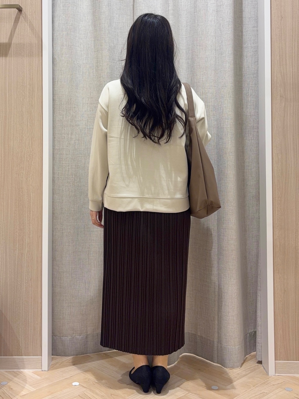 ベージュ系のTシャツ/カットソー、ブラウン系のスカート、ブラウン系のショルダーバッグを着用したレディースの秋コーディネートの3枚目の写真
