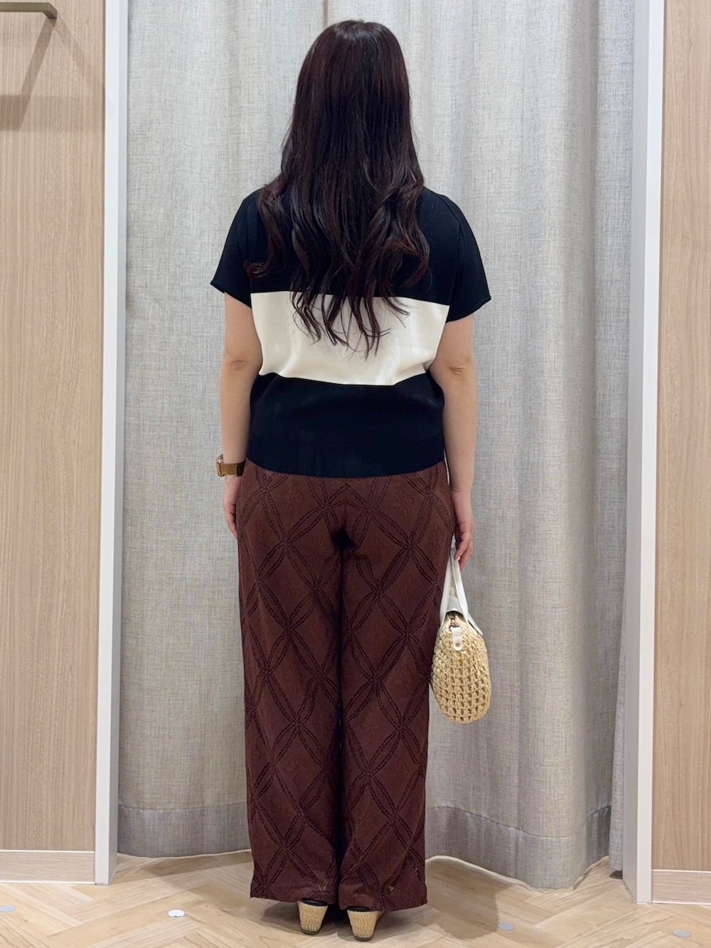 ブラック系のニット/セーター、ブラウン系のその他パンツ、ホワイト系のショルダーバッグを着用したレディースの夏コーディネートの3枚目の写真
