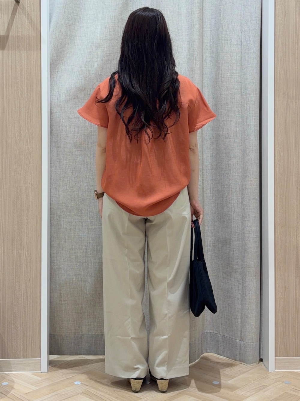 ベージュ系のその他パンツ、ブラック系のトートバッグ、ピンク系のネックレスを着用したレディースの夏コーディネートの3枚目の写真
