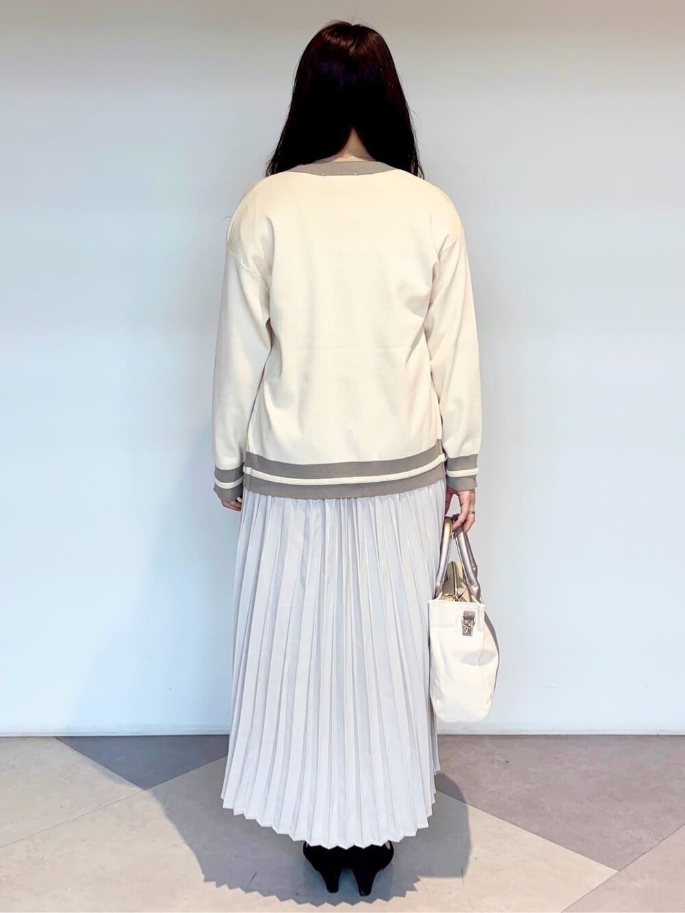 シルバー系のトートバッグ、ブラック系のパンプスを着用したレディースの秋コーディネートの3枚目の写真