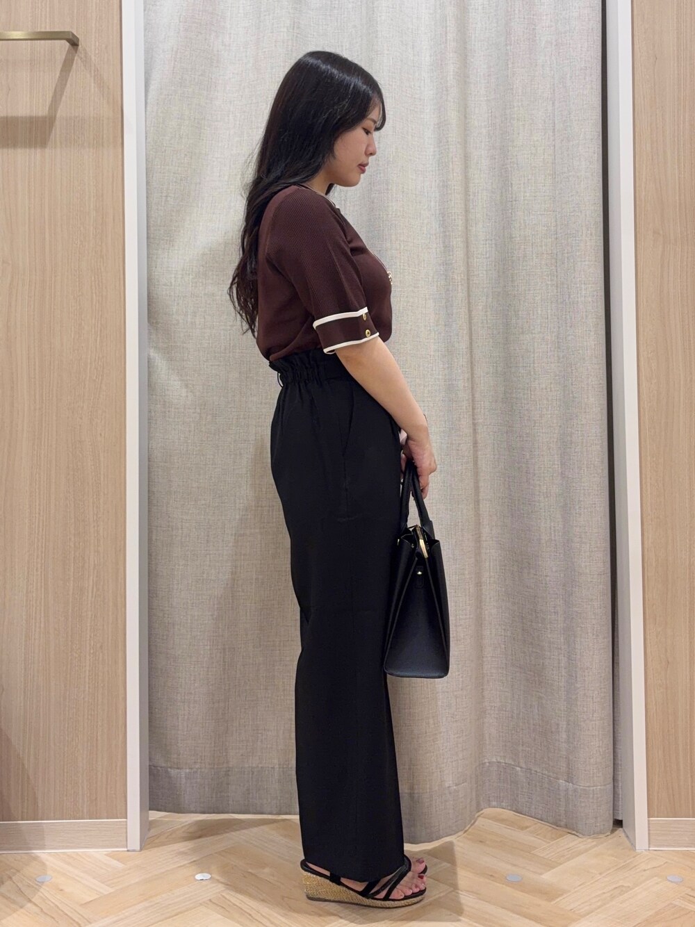ブラウン系のニット/セーター、ブラック系のその他パンツ、ブラック系のトートバッグを着用したレディースの秋コーディネートの2枚目の写真