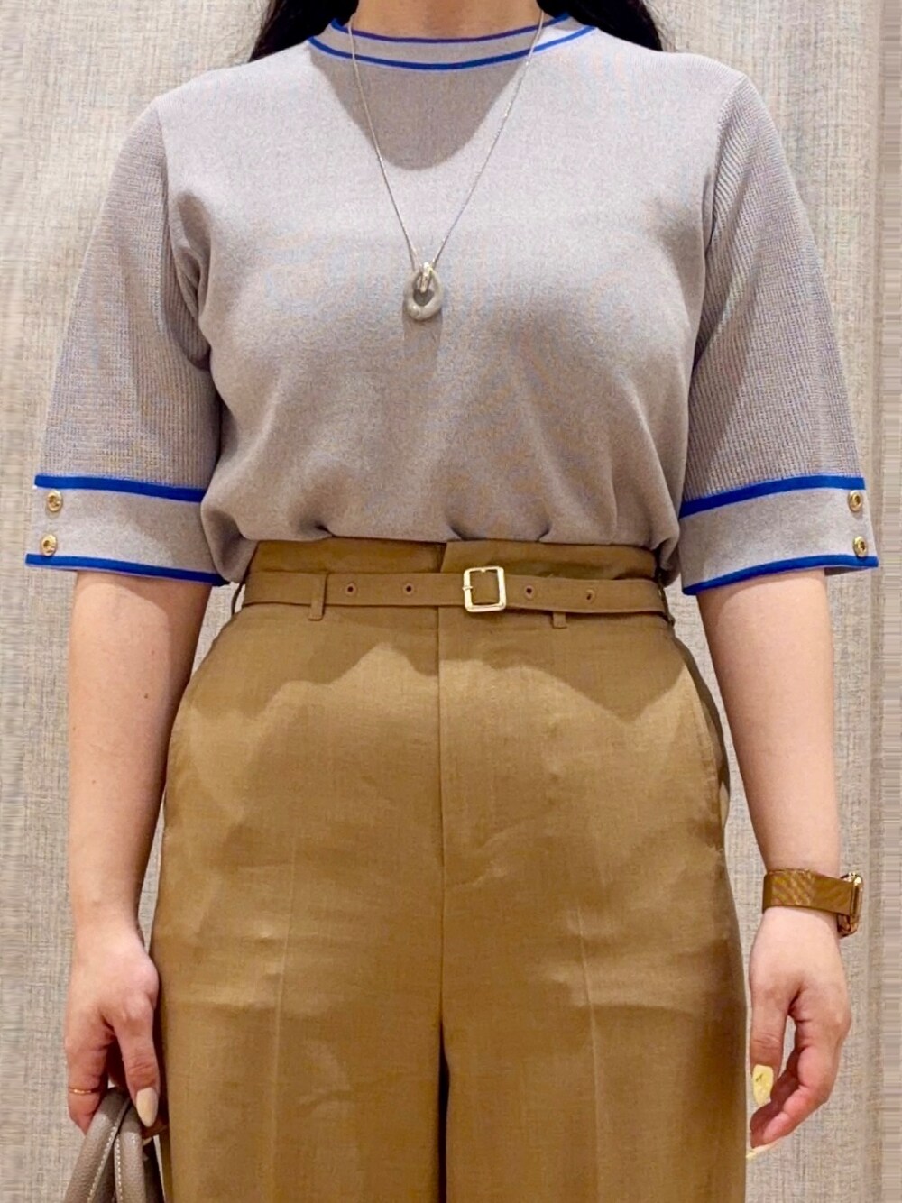 ブラック系のパンプス、ベージュ系のトレンチコート、グレー系のニット/セーターを着用したレディースの春コーディネートの4枚目の写真