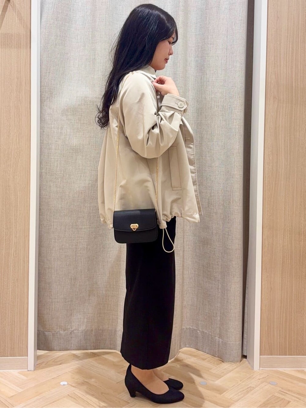 ブラック系のパンプス、ベージュ系のトレンチコート、レッド系のニット/セーターを着用したレディースの春コーディネートの2枚目の写真
