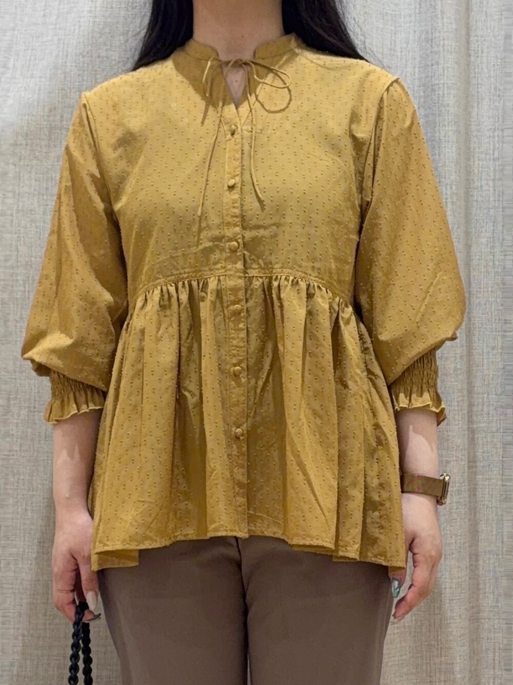 イエロー系のシャツ/ブラウス、ブラウン系のその他パンツ、ブラック系のショルダーバッグを着用したレディースの秋コーディネートの4枚目の写真