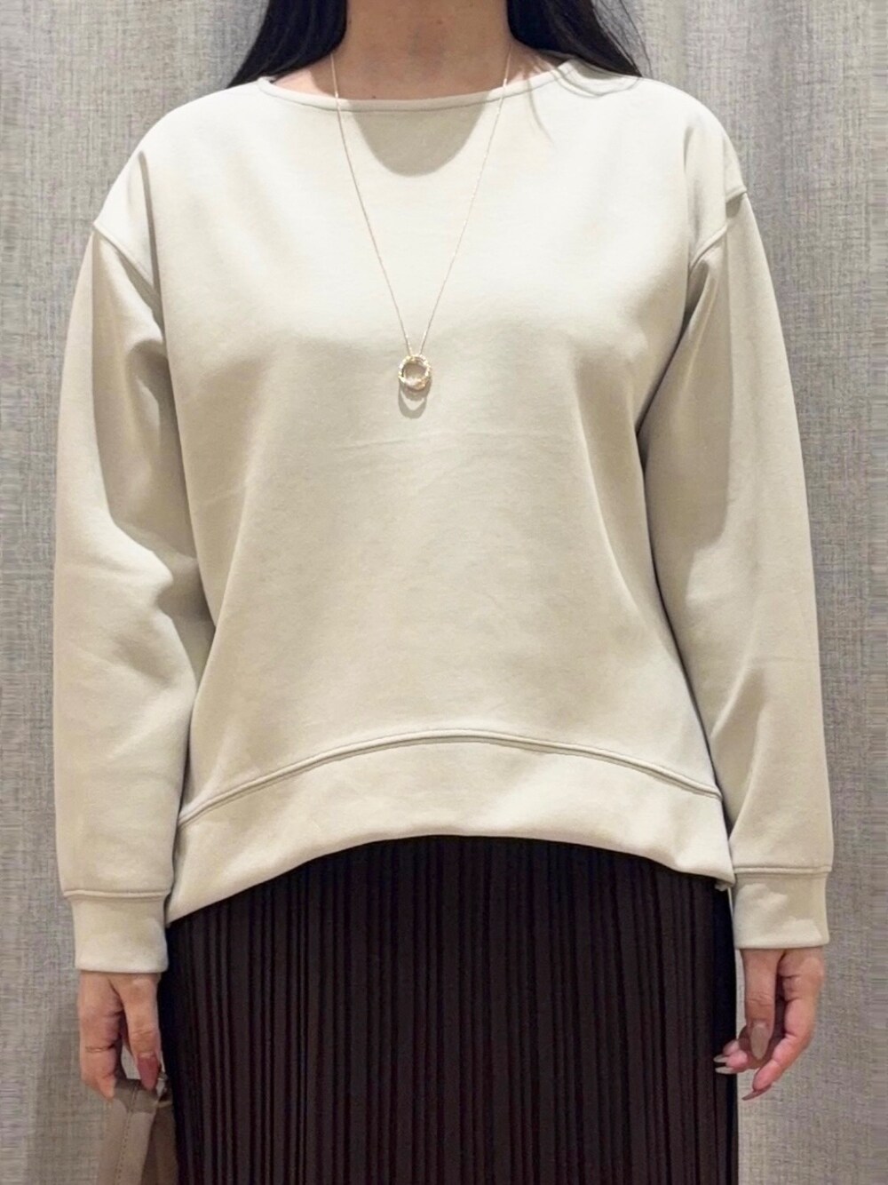 ベージュ系のTシャツ/カットソー、ブラウン系のスカート、ブラウン系のショルダーバッグを着用したレディースの秋コーディネートの4枚目の写真