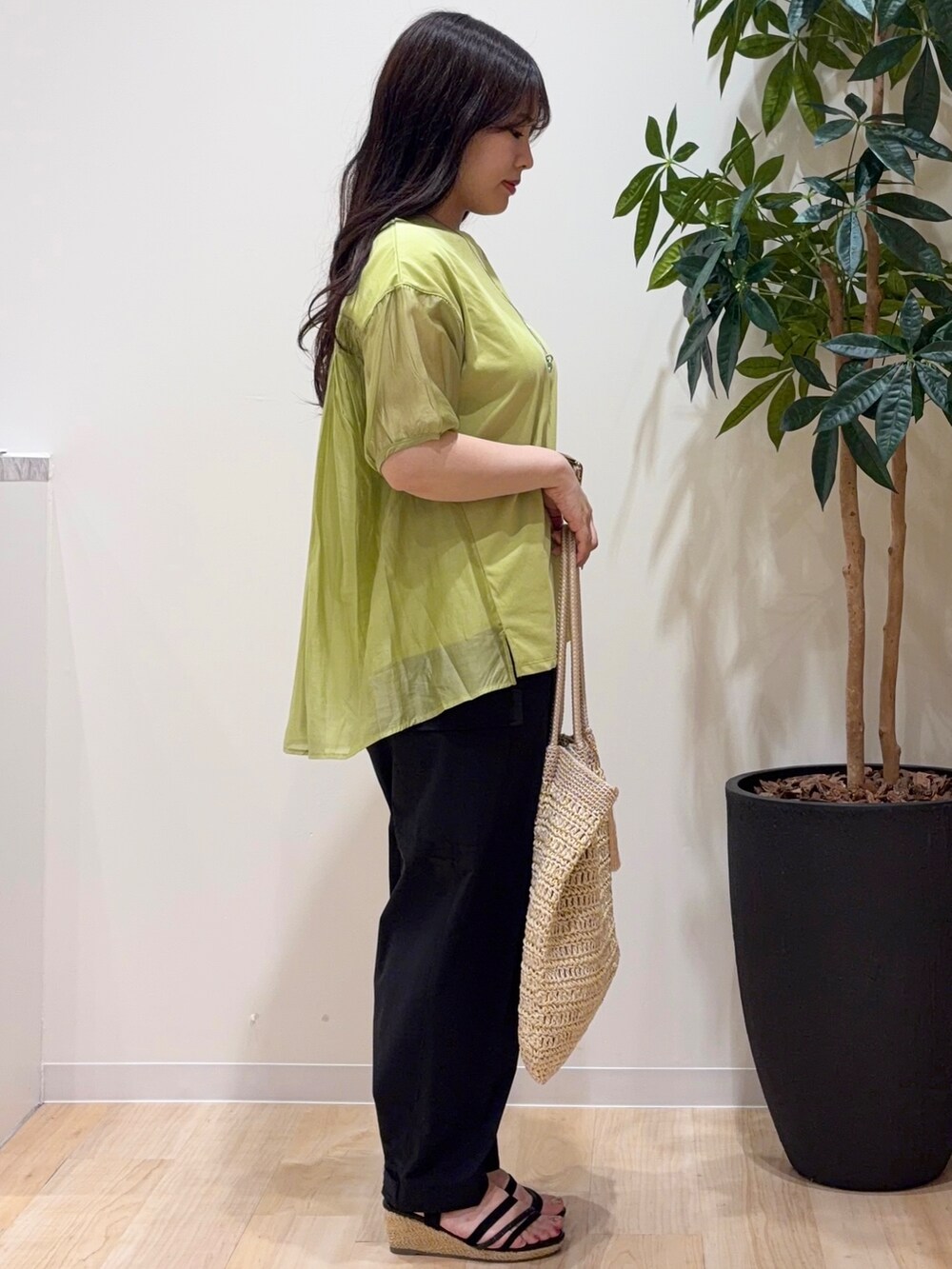 グリーン系のTシャツ/カットソー、ブラック系のその他パンツ、ベージュ系のトートバッグを着用したレディースの夏コーディネートの2枚目の写真