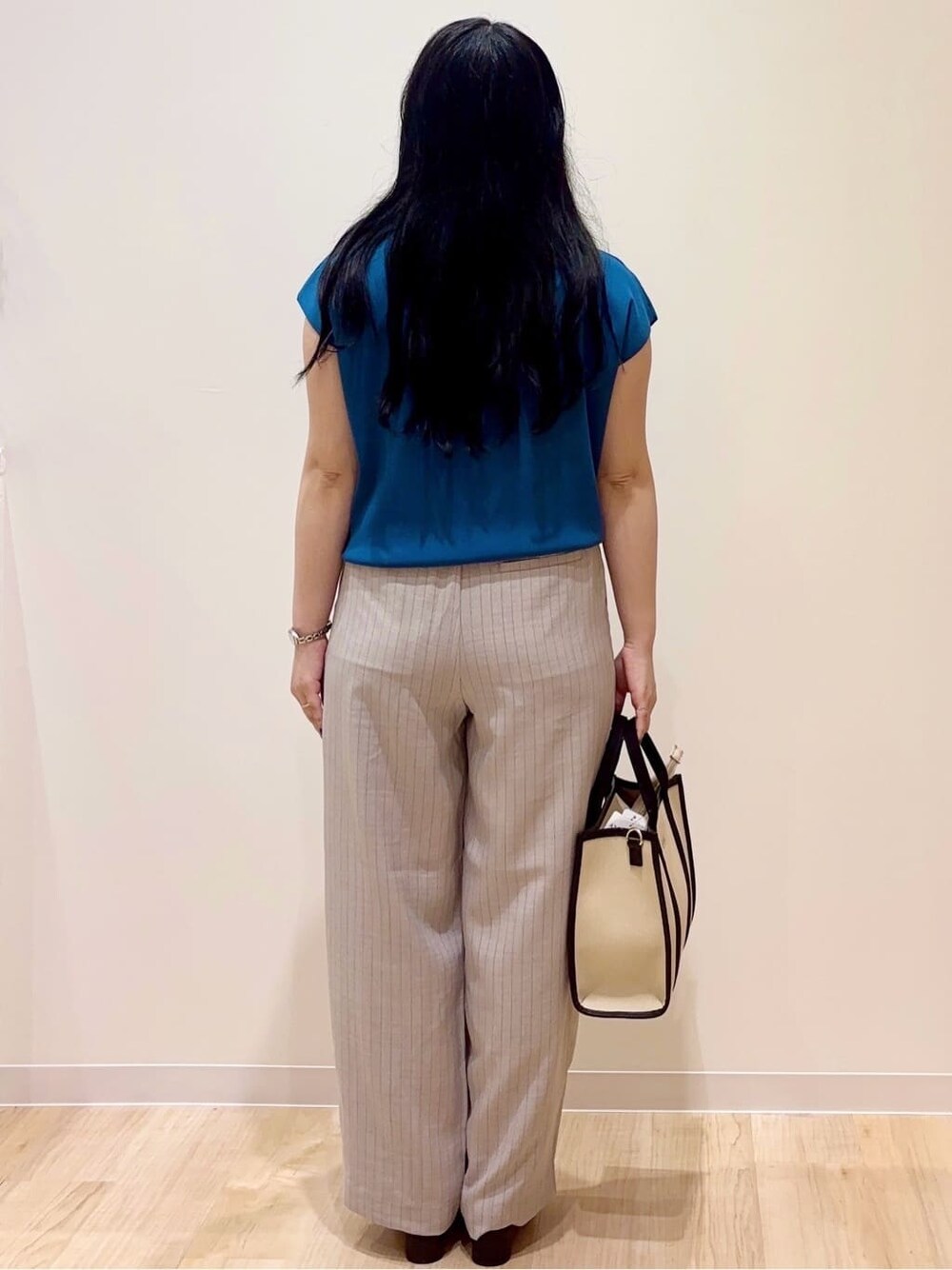 グレー系のその他パンツ、ブラック系のトートバッグ、シルバー系のネックレスを着用したレディースの夏コーディネートの3枚目の写真