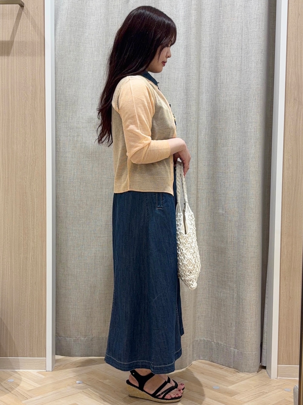 オレンジ系のカーディガン/ボレロ、ブルー系のワンピース、ホワイト系のトートバッグを着用したレディースの夏コーディネートの2枚目の写真