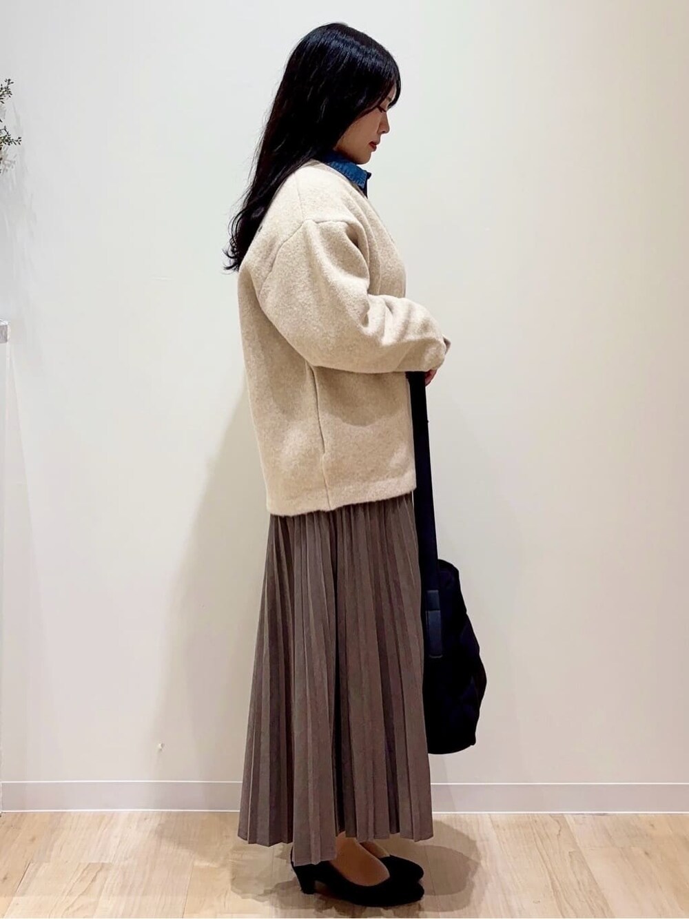 ベージュ系のカーディガン/ボレロ、ブルー系のシャツ/ブラウス、ブラウン系のスカートを着用したレディースの秋コーディネートの2枚目の写真