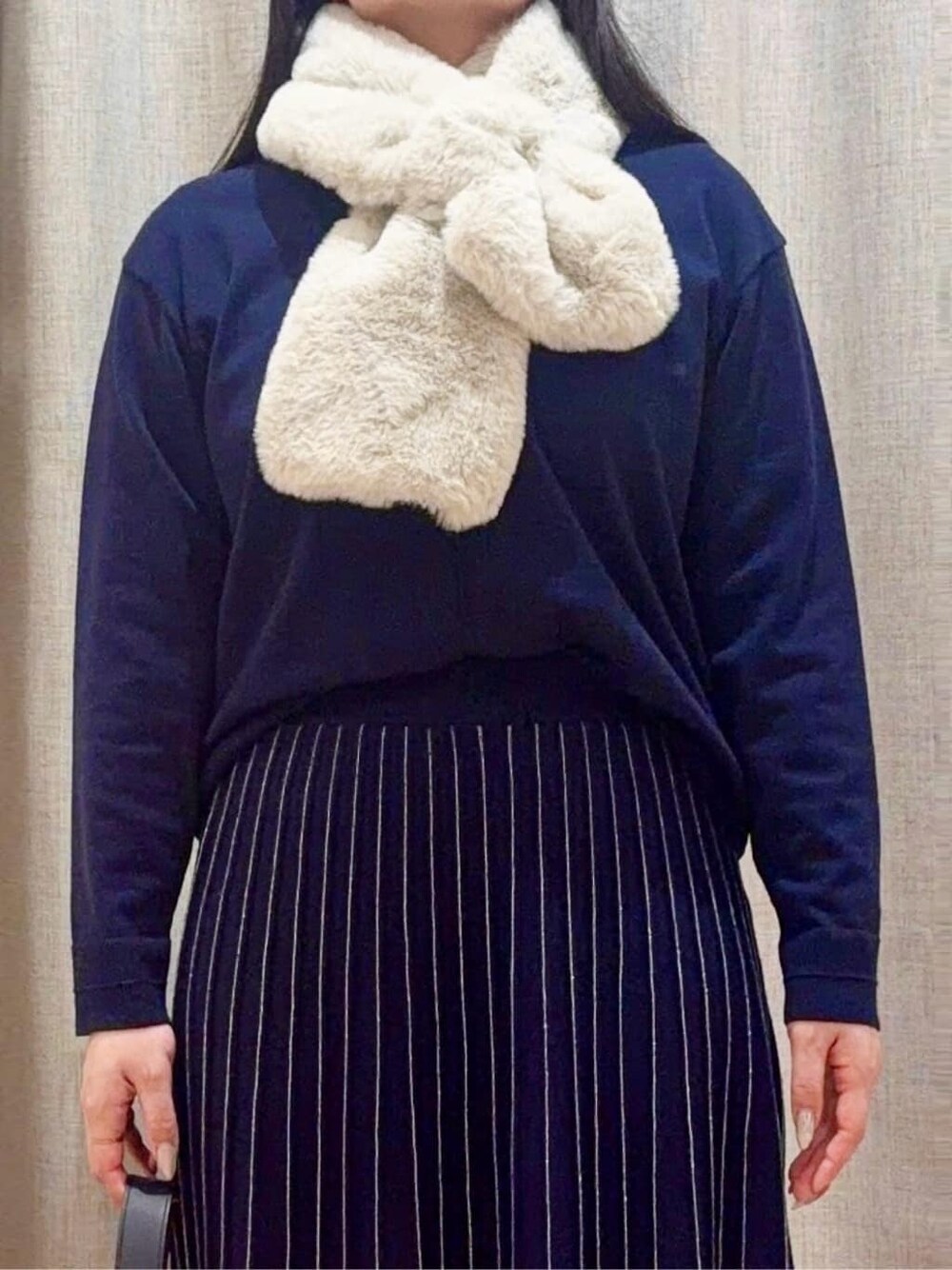 ブルー系のニット/セーター、ブルー系のスカート、グレー系のショルダーバッグを着用したレディースの冬コーディネートの4枚目の写真