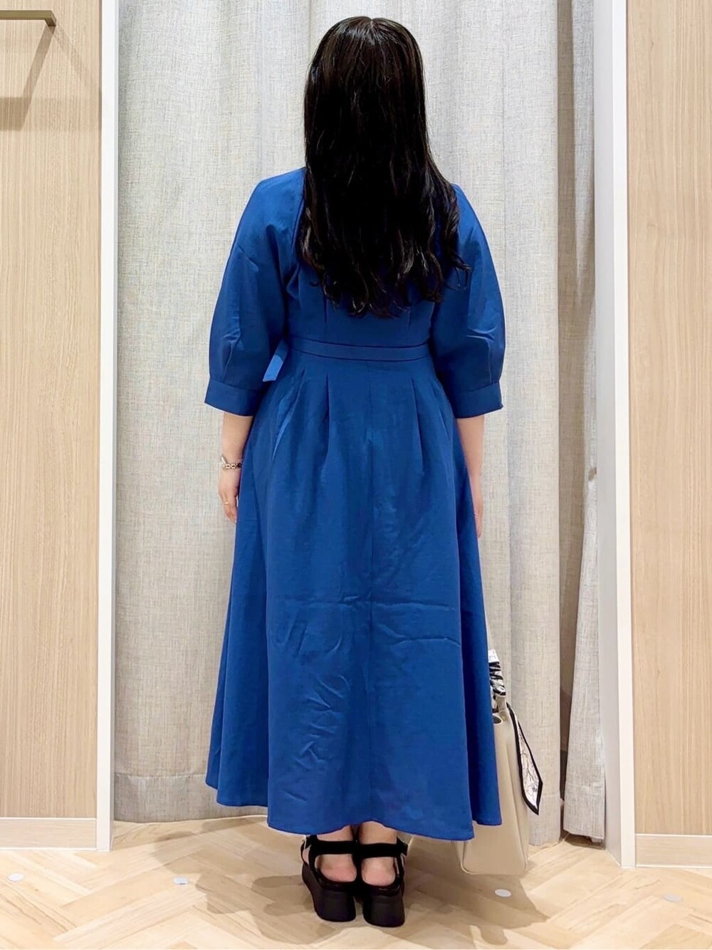 ブルー系のワンピース、グレー系のトートバッグ、シルバー系のネックレスを着用したレディースの夏コーディネートの3枚目の写真