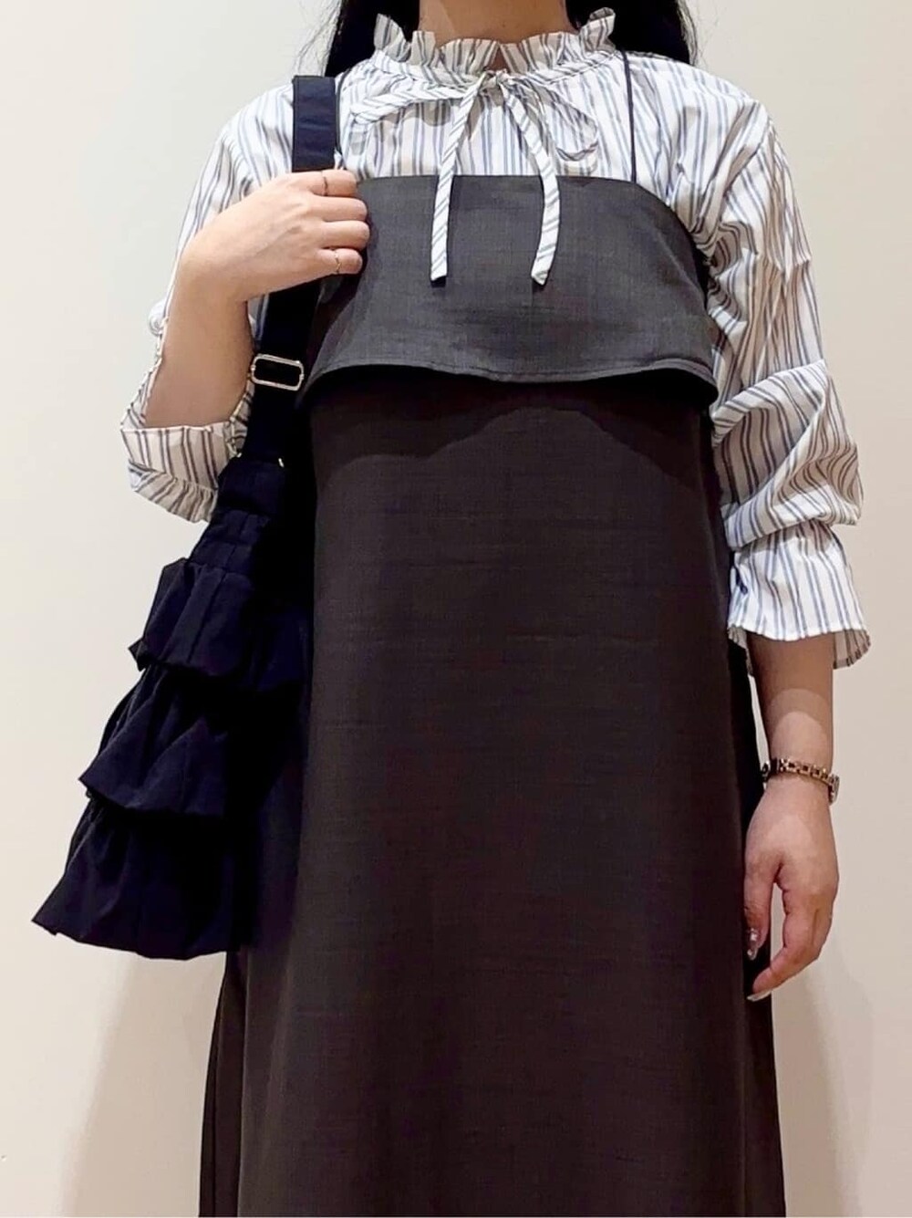 ブルー系のシャツ/ブラウス、ブラウン系のワンピース、ブラック系のショルダーバッグを着用したレディースの秋コーディネートの4枚目の写真