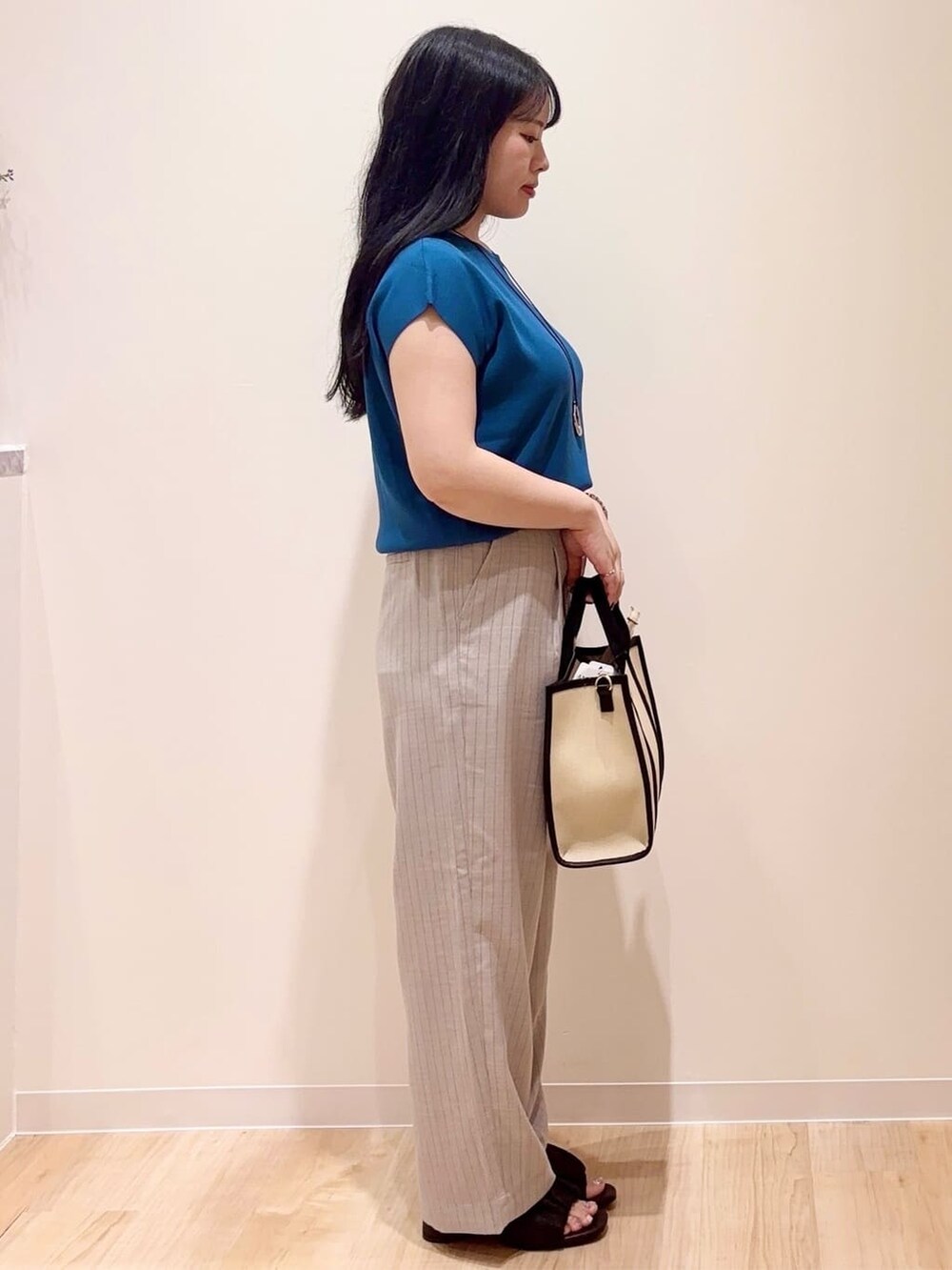 グレー系のその他パンツ、ブラック系のトートバッグ、シルバー系のネックレスを着用したレディースの夏コーディネートの2枚目の写真