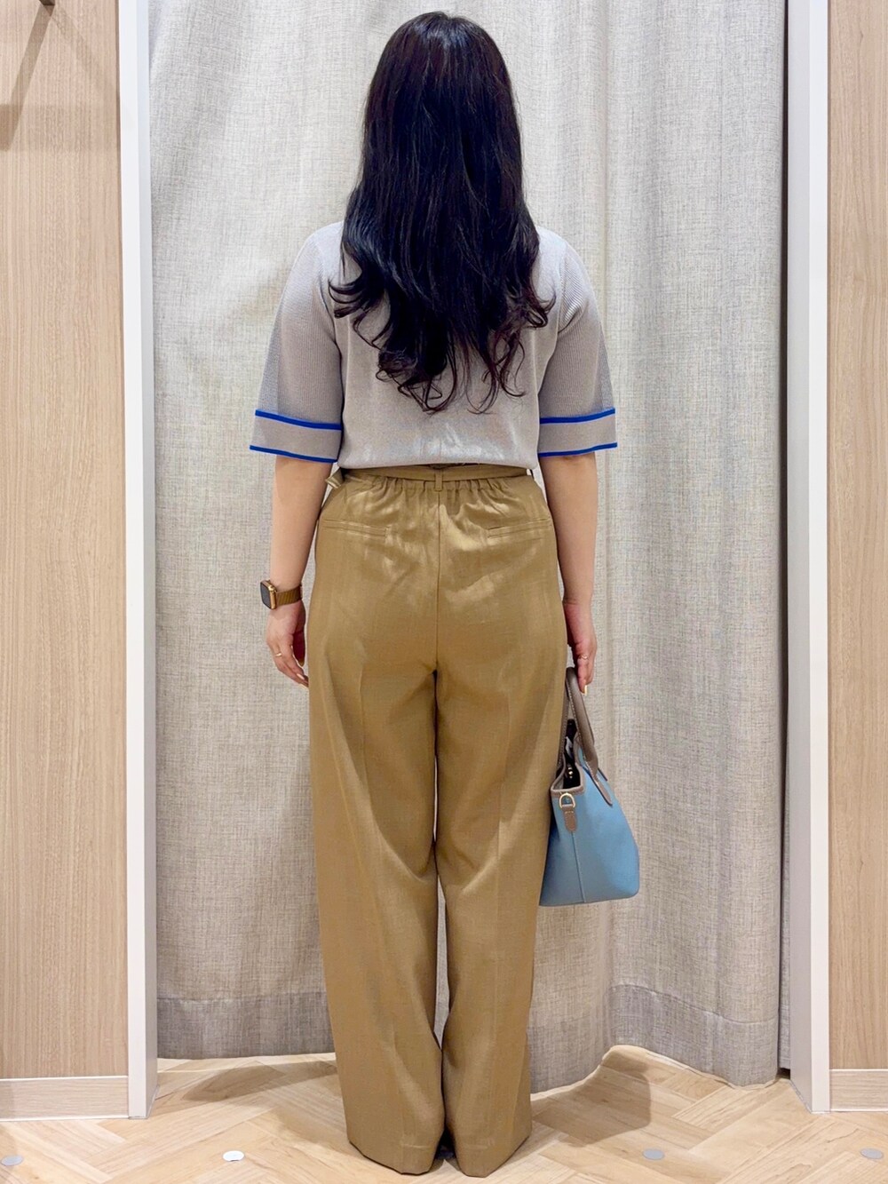 ブラック系のパンプス、ベージュ系のトレンチコート、グレー系のニット/セーターを着用したレディースの春コーディネートの3枚目の写真