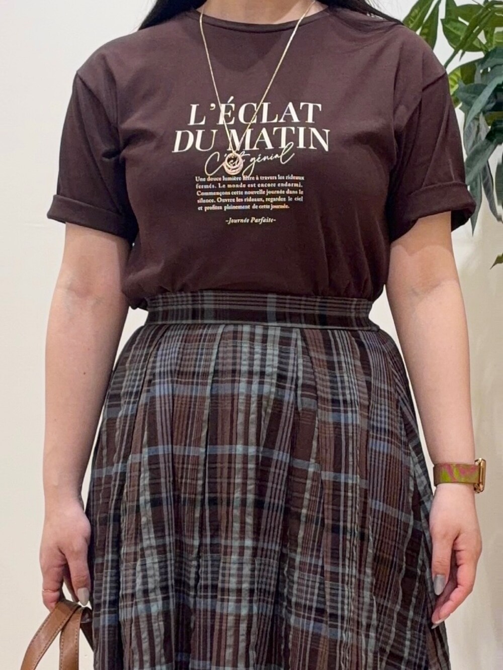 ブラウン系のスカート、ブラウン系のTシャツ/カットソー、ブラック系のサンダルを着用したレディースの春コーディネートの4枚目の写真