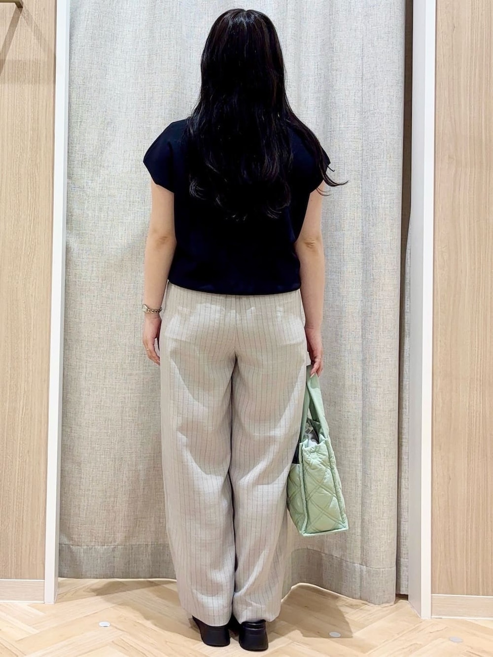 グレー系のその他パンツ、グリーン系のトートバッグ、シルバー系のネックレスを着用したレディースの夏コーディネートの3枚目の写真