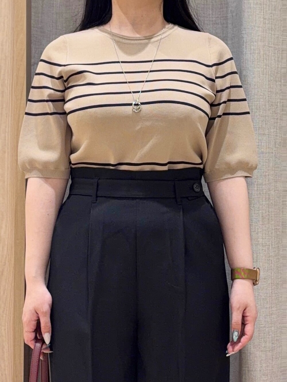 ベージュ系のニット/セーター、ブラック系のその他パンツ、レッド系のショルダーバッグを着用したレディースの夏コーディネートの4枚目の写真