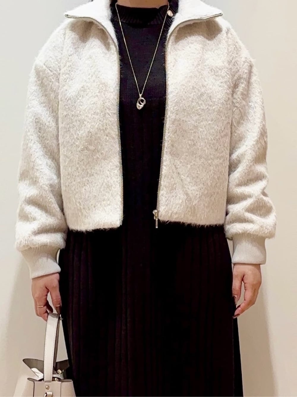 ベージュ系のブルゾン、グレー系のワンピース、グレー系のショルダーバッグを着用したレディースの冬コーディネートの4枚目の写真