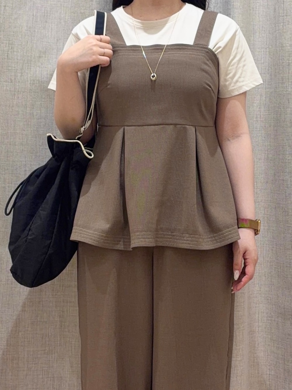 ベージュ系のTシャツ/カットソー、ブラック系のショルダーバッグ、ゴールド系のネックレスを着用したレディースの夏コーディネートの3枚目の写真