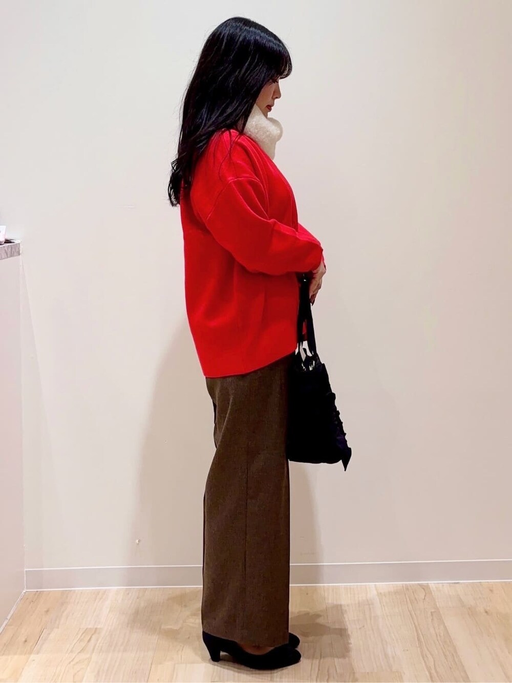 レッド系のカーディガン/ボレロ、ホワイト系のニット/セーター、ブラウン系のその他パンツを着用したレディースの秋コーディネートの2枚目の写真