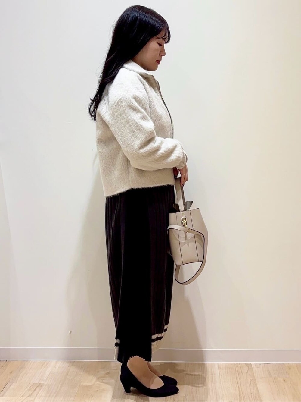 ベージュ系のブルゾン、グレー系のワンピース、グレー系のショルダーバッグを着用したレディースの冬コーディネートの2枚目の写真