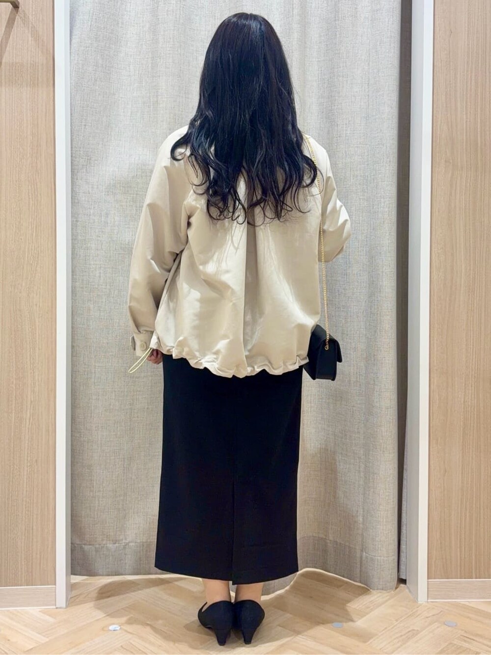 ブラック系のパンプス、ベージュ系のトレンチコート、レッド系のニット/セーターを着用したレディースの春コーディネートの3枚目の写真