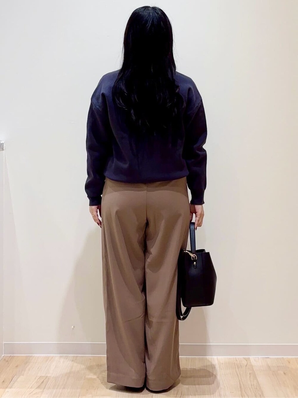 グレー系のニット/セーター、ブラウン系のその他パンツ、ブラック系のショルダーバッグを着用したレディースの秋コーディネートの3枚目の写真