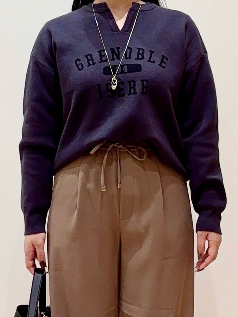 グレー系のニット/セーター、ブラウン系のその他パンツ、ブラック系のショルダーバッグを着用したレディースの秋コーディネートの4枚目の写真