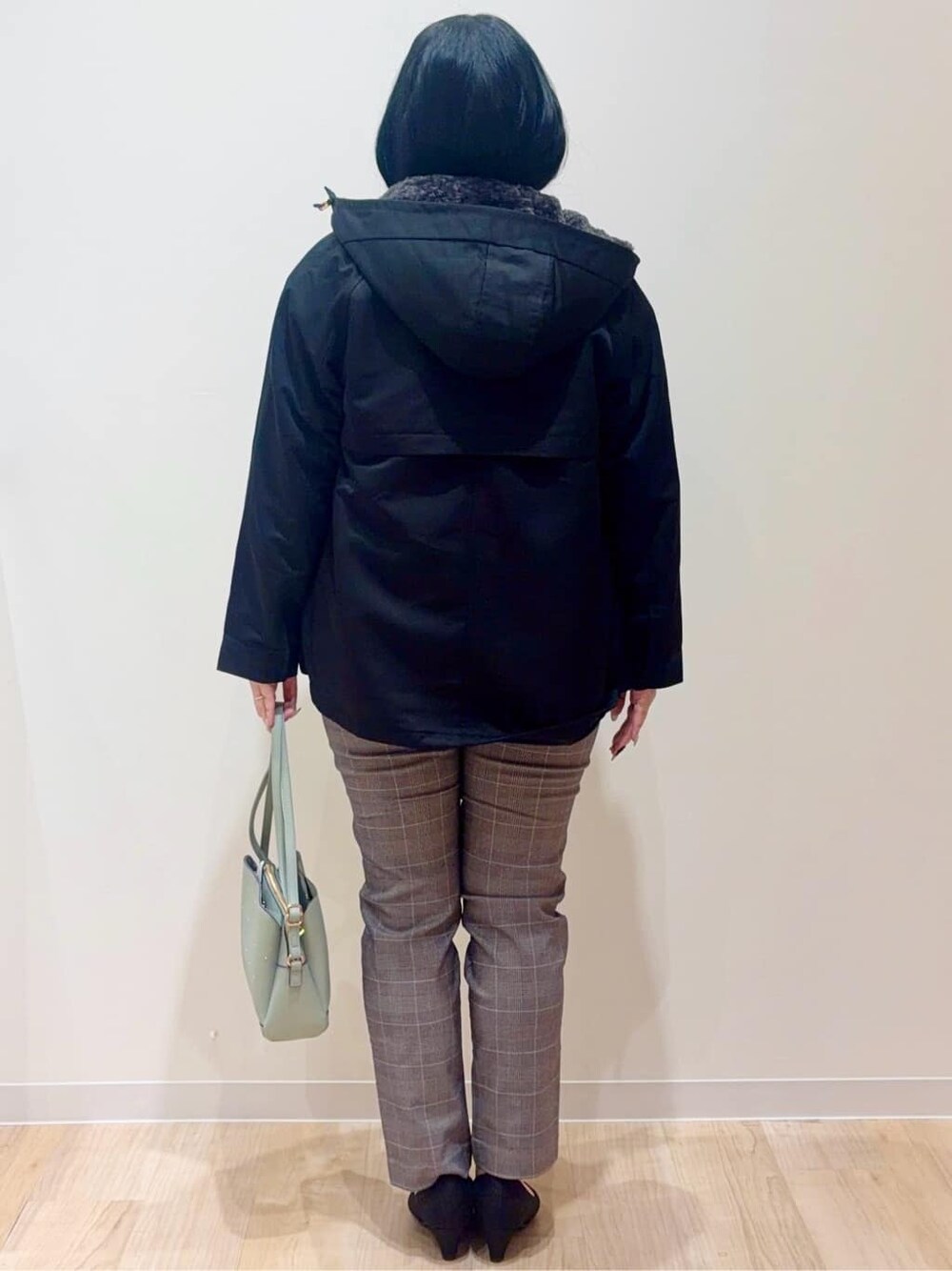 ブラック系のブルゾン、ホワイト系のニット/セーター、ベージュ系のその他パンツを着用したレディースの冬コーディネートの3枚目の写真