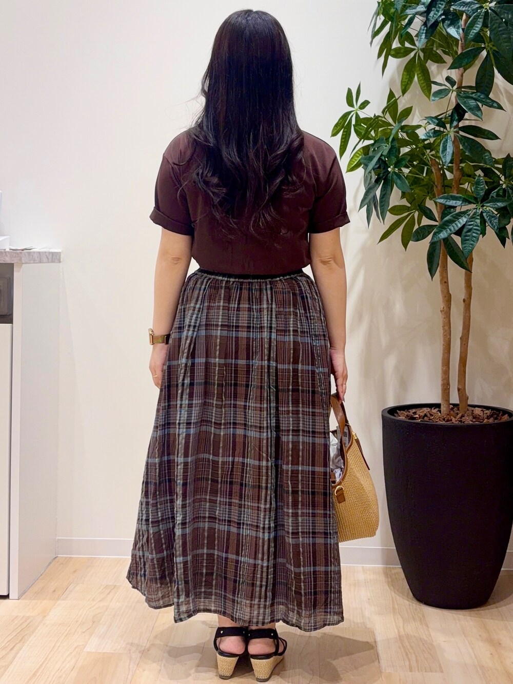 ブラウン系のスカート、ブラウン系のTシャツ/カットソー、ブラック系のサンダルを着用したレディースの春コーディネートの3枚目の写真