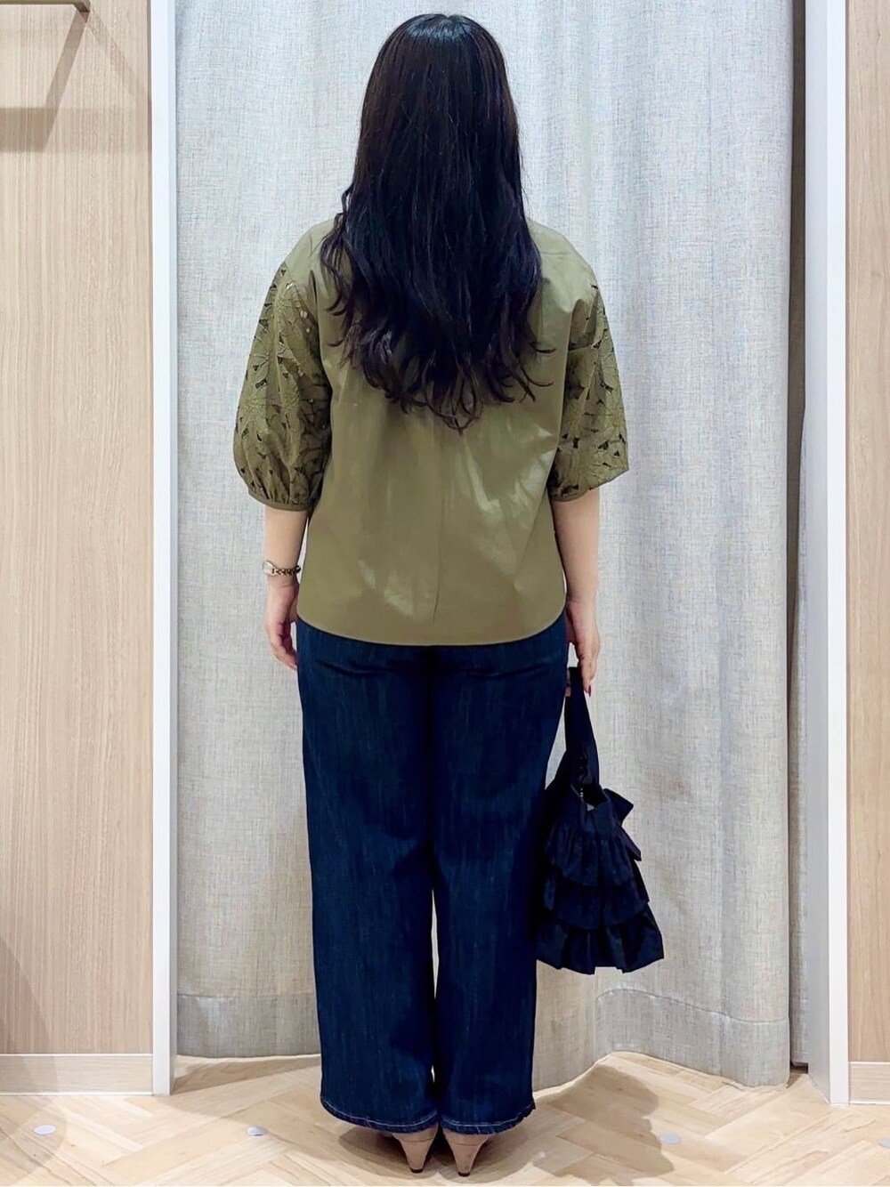 ブルー系のデニムパンツ、ブラック系のトートバッグ、ブラウン系のパンプスを着用したレディースの夏コーディネートの3枚目の写真