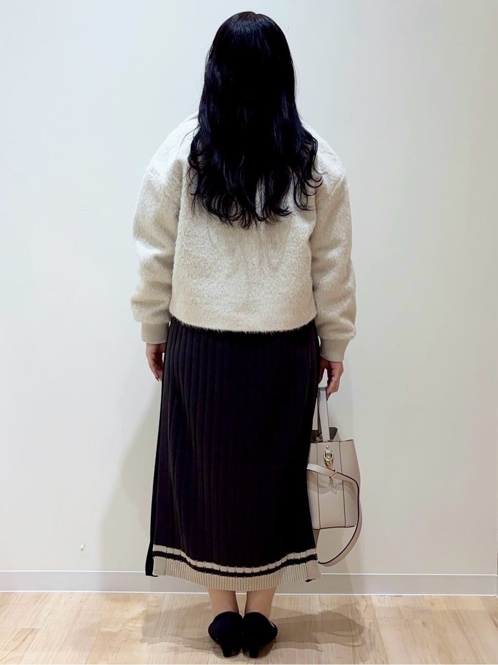 ベージュ系のブルゾン、グレー系のワンピース、グレー系のショルダーバッグを着用したレディースの冬コーディネートの3枚目の写真