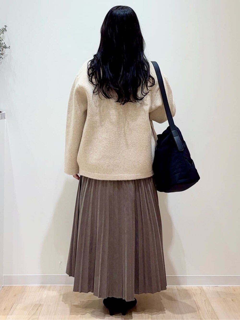 ベージュ系のカーディガン/ボレロ、ブルー系のシャツ/ブラウス、ブラウン系のスカートを着用したレディースの秋コーディネートの3枚目の写真